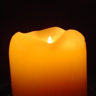 Orange Candle in the Dark photo of orange candle with flame burning in the darkness