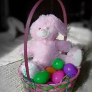 colorized photo of stuffed bunny in an easter basket with colorful eggs