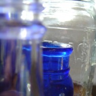 photo of clear and cobalt blue glass bottles and jars