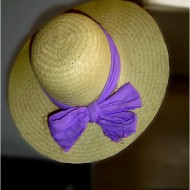 Straw Hat with Purple Bow Photo of straw hat hanging on edge of a chair