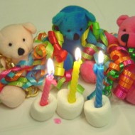 Teddy Bears With Birthday Ribbons and Candles Photo of three teddy bears with colorful birthday ribbons and candles