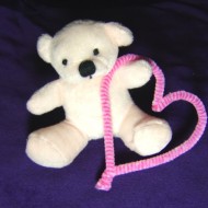 Photo of White Teddy bear holding a pink heart