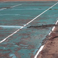 tennis court in disrepair Free photo of a tennis court with badly damaged asphalt