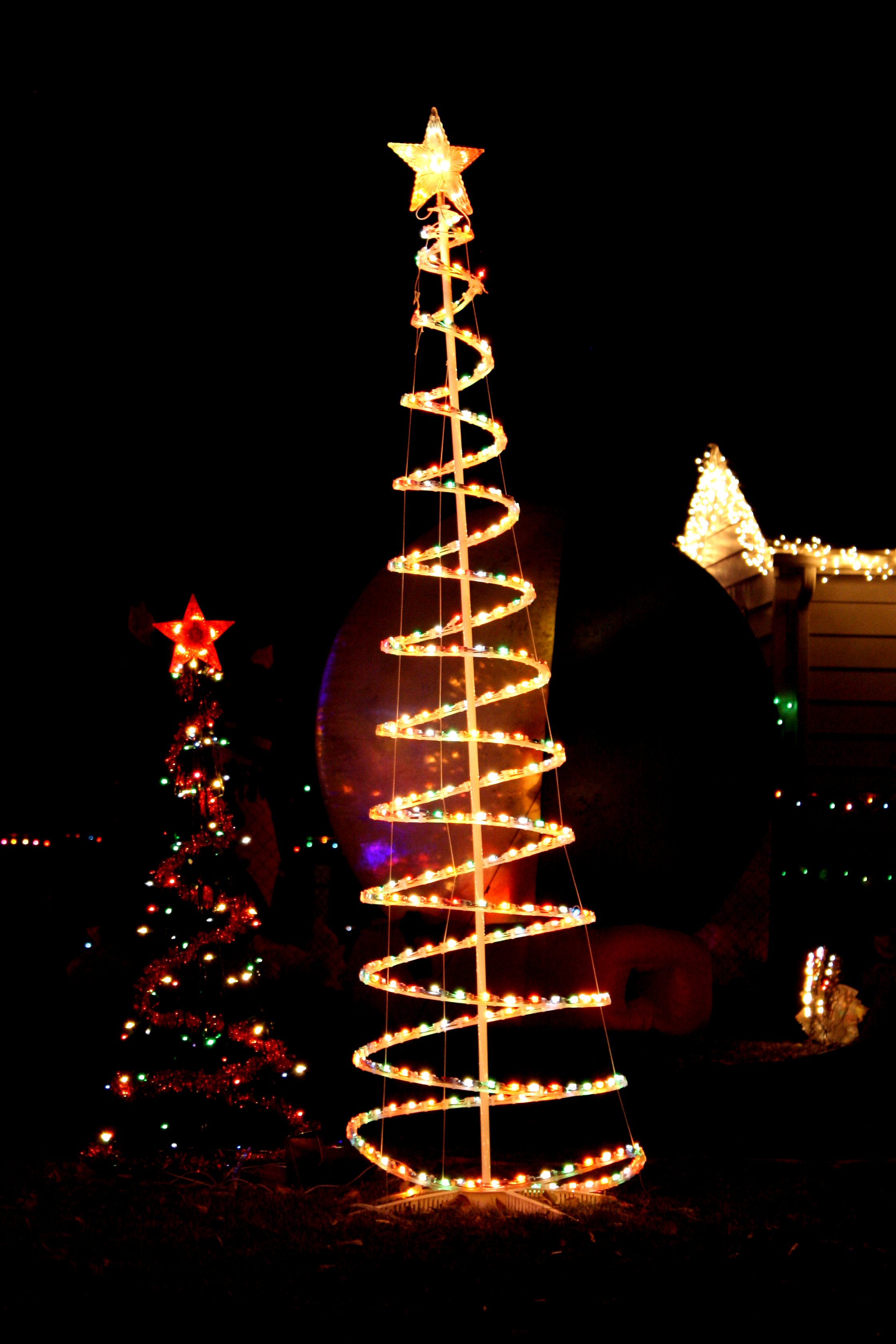 lighted holiday yard decorations in the form of christmas trees ...