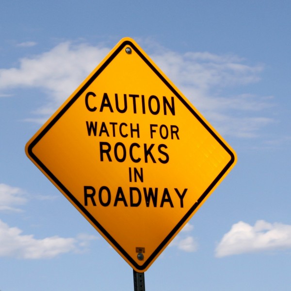 Caution Rocks in Roadway Sign - Free Photo