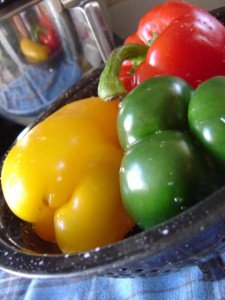 three bell peppers with reflection in silver bowl