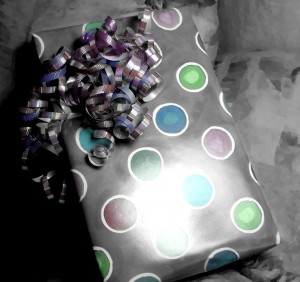 black and white colorized photo of a wrapped birthday present with curly ribbon