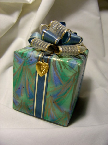 photo of blue and green wrapped package with bow and heart pendant
