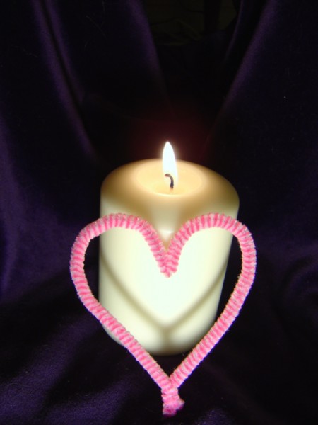 photo of burning lit candle with flame and pink heart