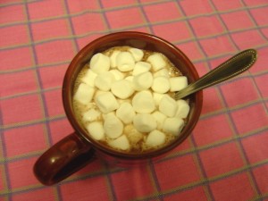 mug full of hot chocolate with mini marshmallows and spoon
