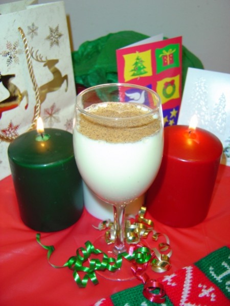 photo of egg nog with christmas candles ribbons and holiday decor