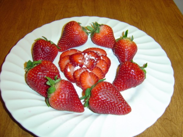 photo of strawberries arranged on a plate with a heart shape
