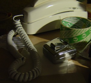 Photo showing tape measure, phone and tape on Cluttered desk