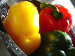 closeup photo of three red yellow and green bell peppers