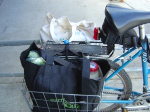 photo of rear bicycle baskets full of bags of groceries