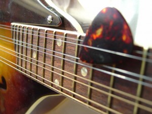 photo of mandolin fingerboard with pick in strings