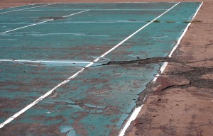 Free photo of a tennis court with badly damaged asphalt