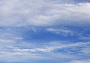 Free photograph of a blue sky with white clouds and a visible airplane trail
