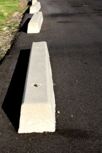 Free photograph of cement parking stops in a parking lot