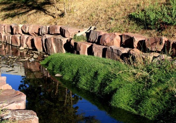 free high resolution photo of a stream with a rock retaining wall