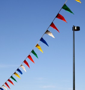 Free photo of a street lamp with pennant flags flying in the wind