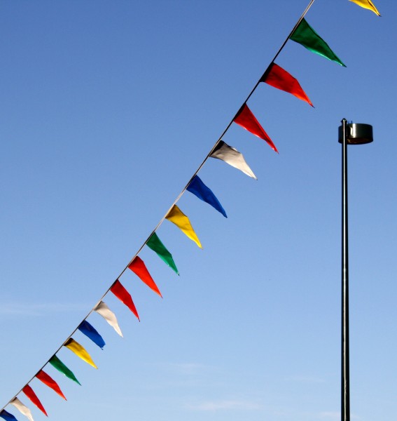 Free photo of a street lamp with pennant flags flying in the wind