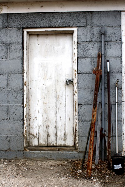 Old Shed Door with Metal Stakes Leaning Next to it Picture 